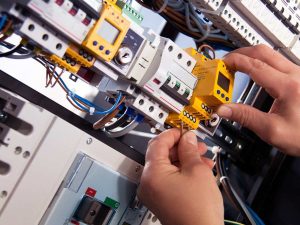 An electrician performing PAT testing on electrical equipment in Bolton, showcasing Electrust Electrical's expertise.